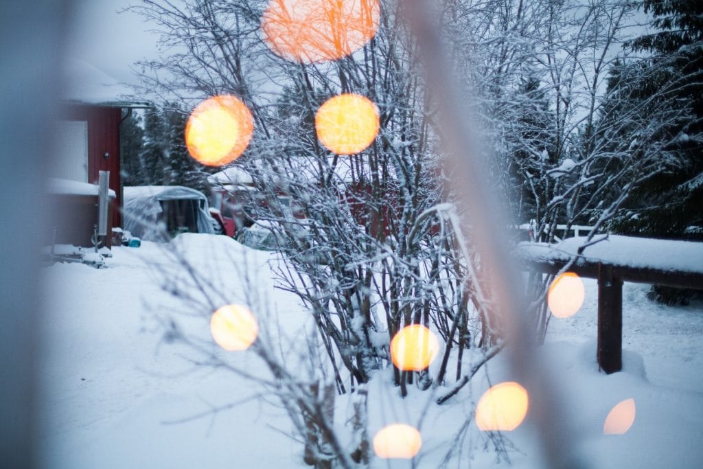 Luminen Ronivaaran pihapiiri nähtynä lämpimien valojen läpi Ronivaaran tallin pihapiirissä Kuusamossa
