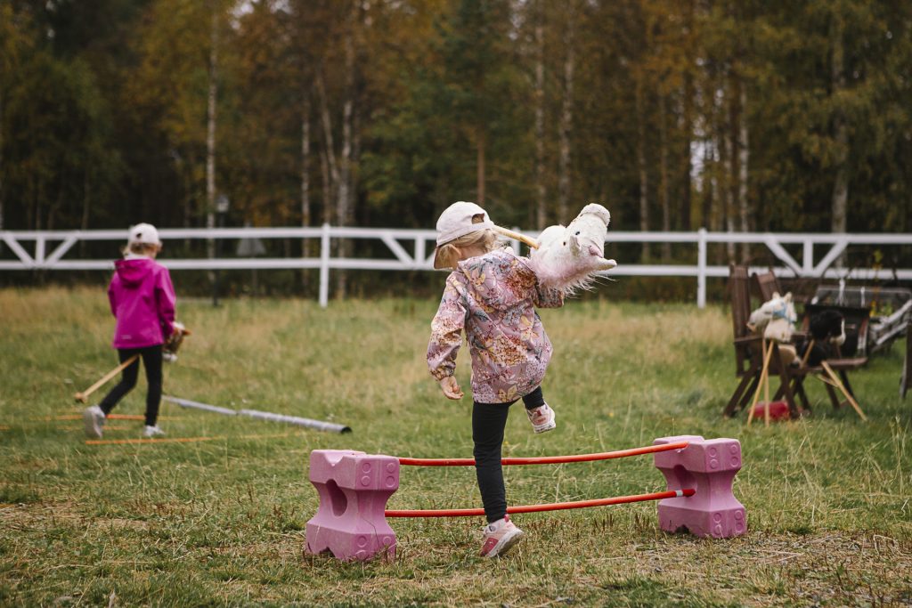 Kaksi lasta kulkee ulkona toiminnallisella esteradalla.